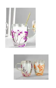Double layer glass coffee mug with real dried flowers inside, heat resistant detail view.