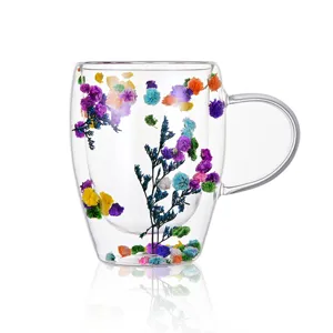 Double walled glass coffee mug with real dried colorful flowers inside, clear aesthetic gift cup.