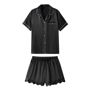 Détails de l'ensemble pyjama en satin de soie noir, haut et shorts avec liseré blanc.