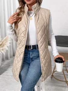 Detailed view of women's beige quilted stand collar zip vest in casual indoor scene setup.