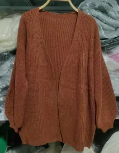 Detailansicht des karamellfarbenen grobgestrickten Cardigans mit V-Ausschnitt und Ärmeln.