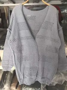 Detail view of women's grey hollow knit cardigan, long sleeve V-neck sweater for daily wear.