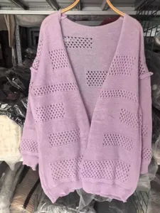 Detail view of women's long-sleeved hollow knitted cardigan in soft purple, casual style.