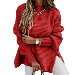 Dettaglio di un maglione rosso in grossa maglia con collo alto e spacco laterale.