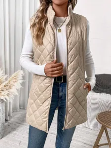 Detailed view of women's beige quilted stand collar puffer vest outfit in indoor setting.