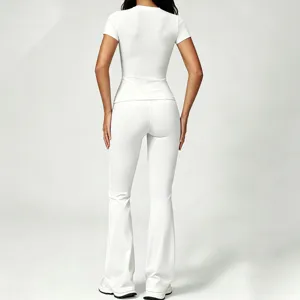 Back view detail of the solid white short sleeve top and high waist flare yoga pants outfit.