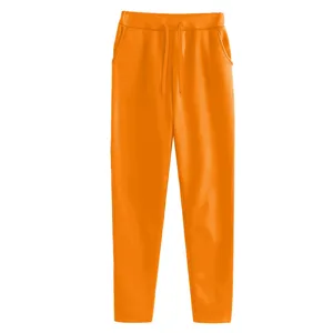 Detailed view of the orange casual fleece sweatpants showing elastic drawstring waist and pockets.