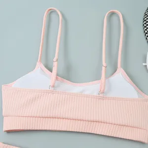 Gros plan détaillé du haut de bikini côtelé rose avec doubles bretelles réglables.