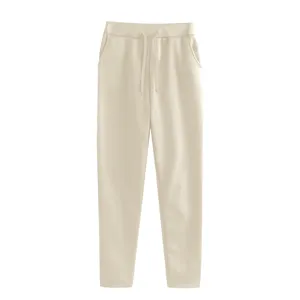 Plain beige casual sweatpants detail view with elastic drawstring waist and side pockets.