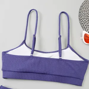 Détail de haut de bikini côtelé avec bretelles fines réglables et tissu mauve texturé.