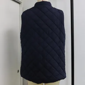 Vista posteriore dettagliata del gilet trapuntato blu scuro con motivo a rombi e collo.