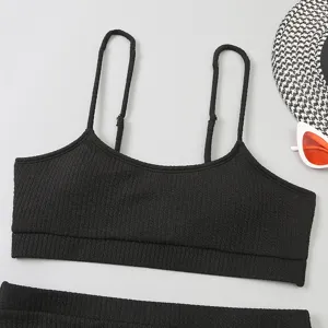 Gros plan sur le haut de bikini noir côtelé montrant une texture fine et un col en U.
