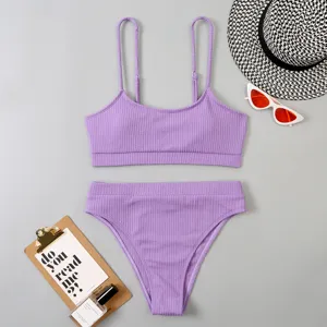 Détail d'ensemble de bikini côtelé violet, disposition à plat avec chapeau et lunettes de soleil.