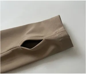 Close up detail of women athletic jacket sleeve with thumb hole, stretchy khaki activewear fabric.