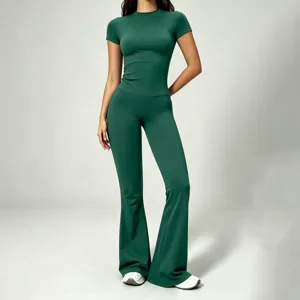 Dark green slim short-sleeve yoga top and high-waist flared pants set, soft workout fabric.