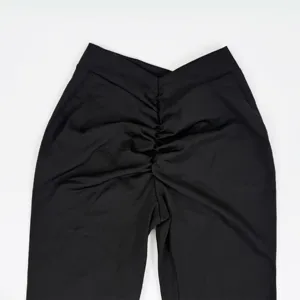 Black V-waist scrunch butt yoga flare pants detail shot showing quick dry athletic fabric.