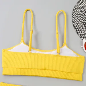 Vue détaillée d'un haut de bikini jaune côtelé avec des bretelles réglables et une doublure.