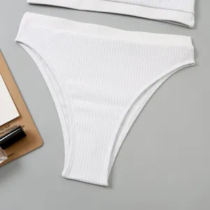 Détail de bas de bikini taille haute côtelé blanc, tissu de maillot texturé doux.