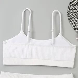 Détail en gros plan du haut de bikini blanc côtelé avec des bretelles réglables.