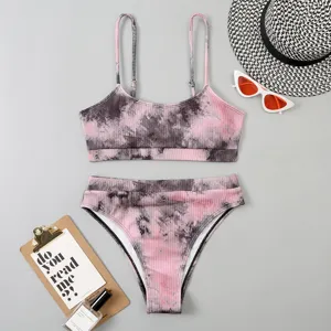 Vue détaillée du bikini taille haute côtelé tie-dye rose avec accessoires de plage d'été.