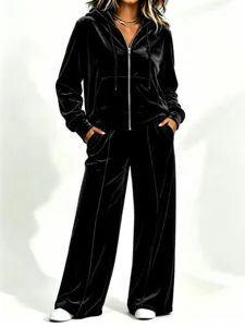 Sweat à capuche en velours noir et pantalon large, détail de tenue de loisir chic.