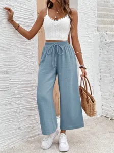 Detail shot of casual light blue wide-leg pants with comfortable drawstring waist style.