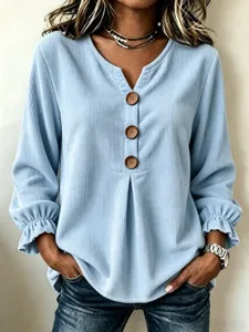 Close-up detail of the light blue corduroy long sleeve shirt featuring V-neck and wooden buttons.