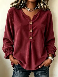 Close-up view of women's corduroy long sleeve V-neck shirt with wooden buttons detail.