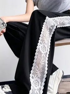 Vista dettagliata di pantaloni casual neri da donna con elegante inserto in pizzo floreale.