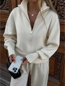 Detailed shot of a women's ribbed knit zip-up cardigan featuring a stand collar and long sleeves.