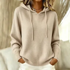 Beige knit hooded sweater detail showcasing cozy fabric, drawstrings, and front pockets.