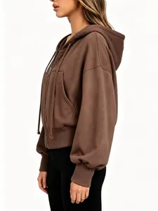 Side view detail of casual brown zip-up hoodie with hood, drawstrings and comfy dropped shoulders.
