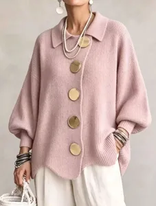 Close-up of pink knit cardigan with large gold buttons, lapel collar, and lantern sleeves.