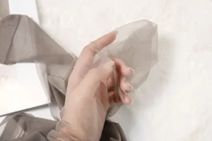 Gros plan sur le tissu de collant gris transparent, texture extensible ultra-fine.