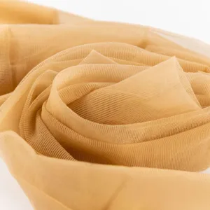 Gros plan du tissu de collants transparents couleur chair avec texture maille fine.