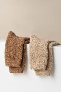 Fuzzy over-the-knee sleep socks detail, soft coral fleece winter leg warmers texture.
