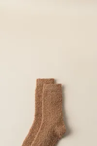 Close-up detail shot of soft brown fuzzy winter sleep socks, comfortable warm plush texture.