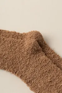 Close-up detail of soft brown coral fleece winter warm leg warmers fabric texture.