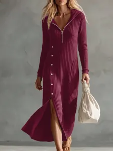 Dettaglio abito lungo in maglia a costine, cappuccio zip frontale e spacco con bottoni.