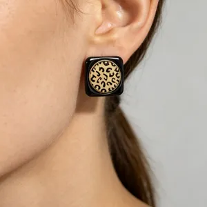 Detalle de pendientes cuadrados con estampado de leopardo y montura negra para mujer.