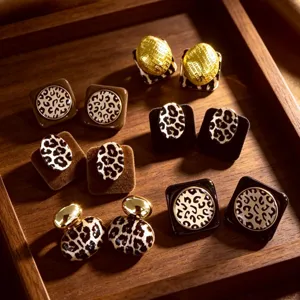 Primer plano de pendientes retro con estampado de leopardo y texturas de terciopelo.