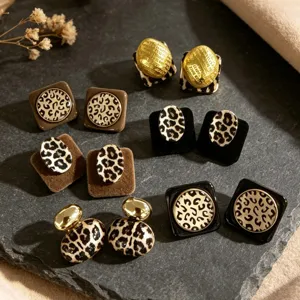 Vista detallada de pendientes de leopardo en metal y terciopelo, estilo elegante.