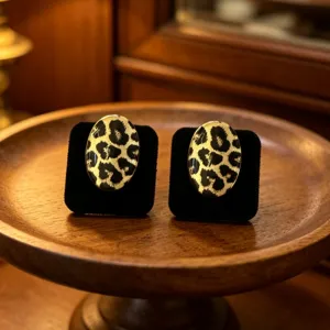 Primer plano de pendientes ovalados vintage con estampado de leopardo en terciopelo.