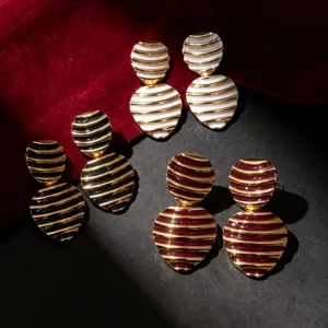 Detailed close-up shot of vintage striped enamel earrings featuring elegant gold-tone metal trim.