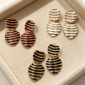 Close-up detail of retro striped enamel heart earrings in multiple colors on a velvet tray.