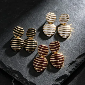 Close-up detail of retro striped heart enamel earrings showing exquisite metal gloss and texture.