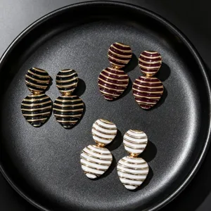 Vintage striped enamel stud earrings detail, elegant geometric metal jewelry accessory.