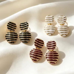 Vintage striped enamel heart drop earrings, retro gold metal geometric jewelry detail view.