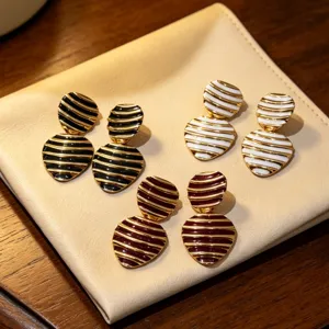 Detailed close-up of vintage striped enamel geometric earrings with metal craftsmanship.