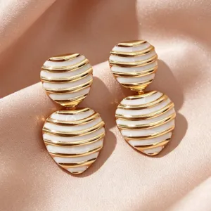 Detailed close-up of vintage striped gold-plated enamel heart earrings, exquisite retro texture.
